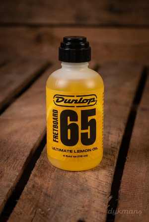 Dunlop 6554 Formula 65 Ultimate Lemon Oil flesje van 118 ml op een warme houten achtergrond
