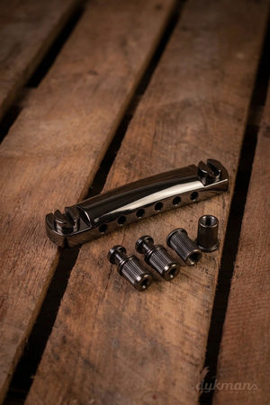 Gibson PTTP-050 Black Chrome stopbar met bevestigingsmateriaal op een houten ondergrond